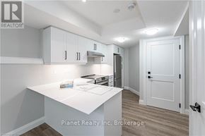 Guelph (Exhibition Park) apartment for rent - A real estate listing image of a kitchen with white cabinets and a white island.
