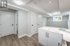 Guelph (Exhibition Park) apartment for rent - A real estate listing photo of a white bedroom with a large bed and a window.