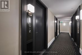 Toronto (Bay Street Corridor) condo for rent - A hallway with a black door and a sign that says "1012" on it.