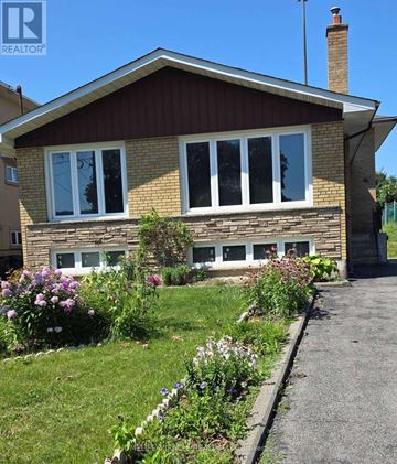 Toronto (Wexford-Maryvale) apartment for rent - A house with a well-kept garden in front.