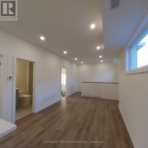 Markham (Cornell) apartment for rent - A spacious room with wooden flooring and white walls.