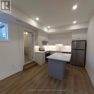 Markham (Cornell) apartment for rent - A kitchen with white cabinets and a refrigerator.
