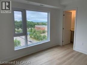 Brantford apartment for rent - A room with a view of a parking lot and trees through a window.