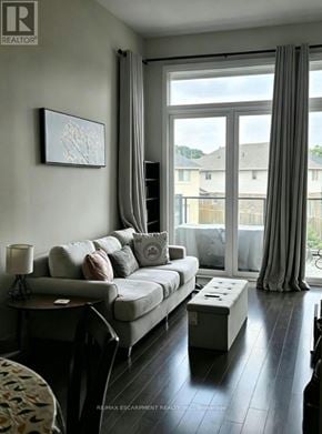 Brantford condo for rent - A living room with a grey couch and a painting on the wall.