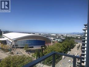 Richmond apartment for rent - A view from a balcony overlooking a stadium and a parking lot.