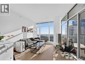 Burnaby apartment for rent - A living room with a grey sofa and a glass table.