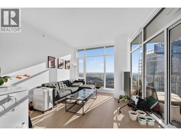 Burnaby apartment for rent - A living room with a grey sofa and a glass table.