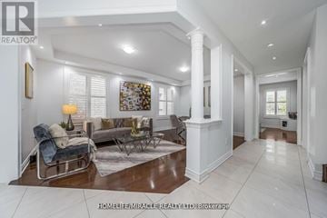 Brampton (Credit Valley) apartment for rent - A spacious living room with a dark blue sofa and a glass coffee table.