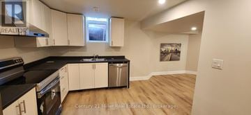 Oakville (Ro River Oaks) apartment for rent - A kitchen with white cabinets and black countertops.