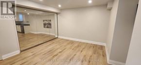 Oakville (Ro River Oaks) apartment for rent - A room with wooden flooring and a glass door leading to another room.