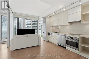 Toronto (Waterfront Communities) condo for rent - A modern kitchen with white cabinets and appliances.