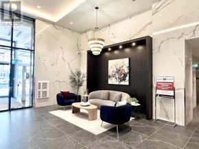 Toronto (Willowdale East) condo for rent - A reception area with a blue sofa and a sign that says "PLAN PLACE".