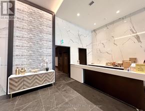 Toronto (Willowdale East) condo for rent - A reception area with a marble wall and a bench.