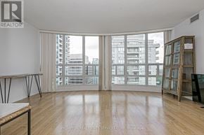 Toronto (Willowdale East) condo for rent - A room with wooden flooring and a large window overlooking a cityscape.