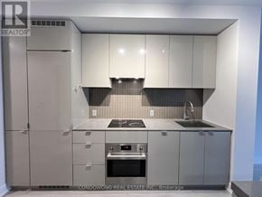 Toronto (Bay Street Corridor) condo for rent - A modern kitchen with grey cabinets and appliances.