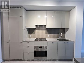 Toronto (Bay Street Corridor) condo for rent - A modern kitchen with grey cabinets and appliances.