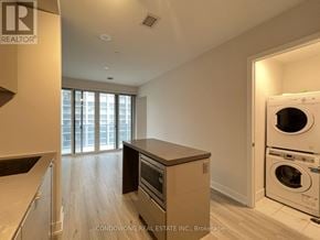 Toronto (Bay Street Corridor) condo for rent - A modern kitchen with wooden floors and a large window.