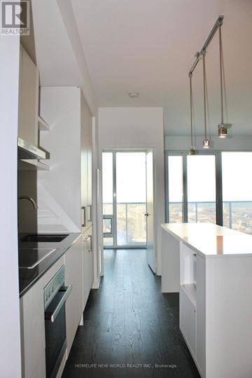 Toronto (Waterfront Communities) condo for rent - A modern kitchen with white cabinets and black countertops.