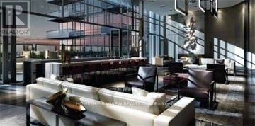 Toronto (Mount Pleasant West) condo for rent - A modern living room with a long couch and a chair.
