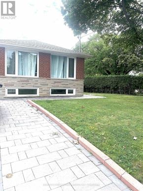 Toronto (Newtonbrook East) apartment for rent - A brick house with a green lawn in front.