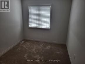 Zorra (Thamesford) townhouse for rent - A room with a window and a brown carpet.