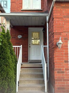 Mississauga (Meadowvale Village) apartment for rent - A red brick house with a white door and stairs leading up to it.
