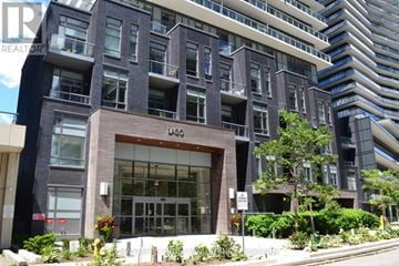 Toronto (Mimico) condo for rent - A modern building with a glass entrance and a sign that reads "REALTOR".