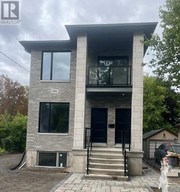 Ottawa duplex for rent - A modern house with a grey and white exterior and a black door.