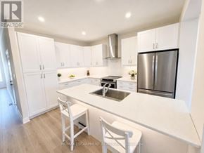 Welland (Coyle Creek) townhouse for rent - A white kitchen with a sink, stove, and refrigerator.