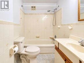 Toronto (Humewood-Cedarvale) triplex for rent - A white toilet is next to a bathtub in a bathroom.