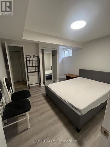 Toronto (L'amoreaux) apartment for rent - A bedroom with a bed, chair, and a small table.
