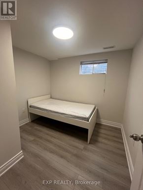 Toronto (L'amoreaux) apartment for rent - A bedroom with a bed, wooden floor, and a window.