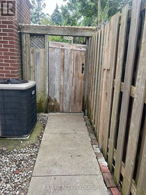 Toronto (L'amoreaux) apartment for rent - A wooden gate leads to a backyard with a concrete walkway.