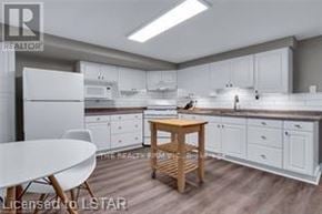 London South (South H) apartment for rent - A modern kitchen with white cabinets and a wooden table.