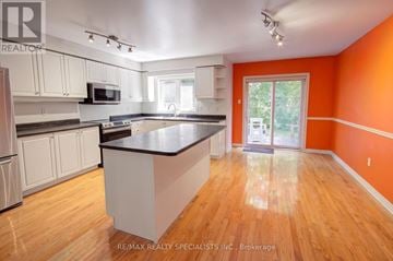 Mississauga (Meadowvale Village) apartment for rent - A kitchen with white cabinets and a black countertop.