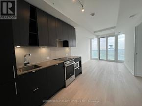 Mississauga (City Centre) condo for rent - A modern kitchen with black cabinets and stainless steel appliances.