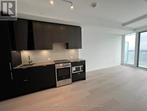 Mississauga (City Centre) condo for rent - A modern kitchen with black cabinets and stainless steel appliances.