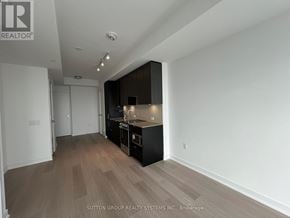 Mississauga (City Centre) condo for rent - A kitchen area with a black cabinet and a white wall.