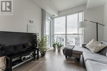 Burlington (Orchard) condo for rent - A living room with a black television and grey couches.