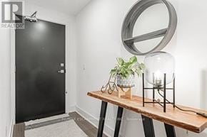 Burlington (Orchard) condo for rent - A black door is on the left of a room with a wooden table and a mirror on the wall.