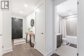 Burlington (Orchard) condo for rent - A bathroom with a black door and a round mirror on the wall.