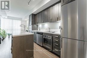 Burlington (Orchard) condo for rent - A modern kitchen with stainless steel appliances and wooden cabinets.