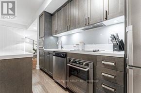Burlington (Orchard) condo for rent - A modern kitchen with stainless steel appliances and wooden cabinets.