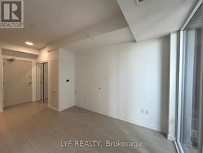 Toronto (Humber Heights) condo for rent - A spacious room with a slanted ceiling and a door on the left.