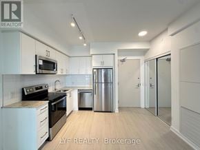 Toronto (Humber Heights) condo for rent - A modern kitchen with white cabinets and stainless steel appliances.