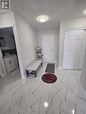 Mississauga (Cooksville) condo for rent - A hallway with a bench and a rug with a logo on it.