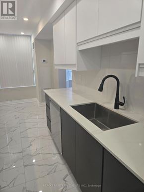 Mississauga (Cooksville) condo for rent - A modern kitchen with a marble floor and a sink with a black faucet.