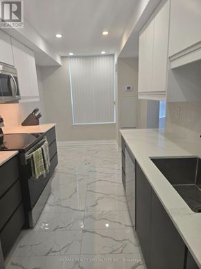 Mississauga (Cooksville) condo for rent - A modern kitchen with marble flooring and white cabinets.