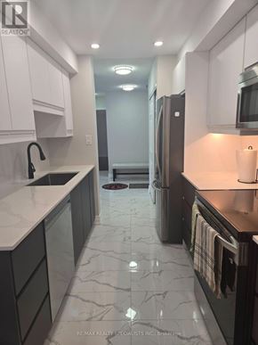 Mississauga (Cooksville) condo for rent - A kitchen with white cabinets and a marble floor.