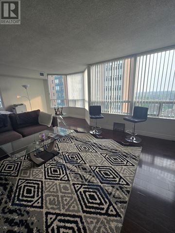 Mississauga (Cooksville) condo for rent - A living room with a rug and a table with a lamp on it.